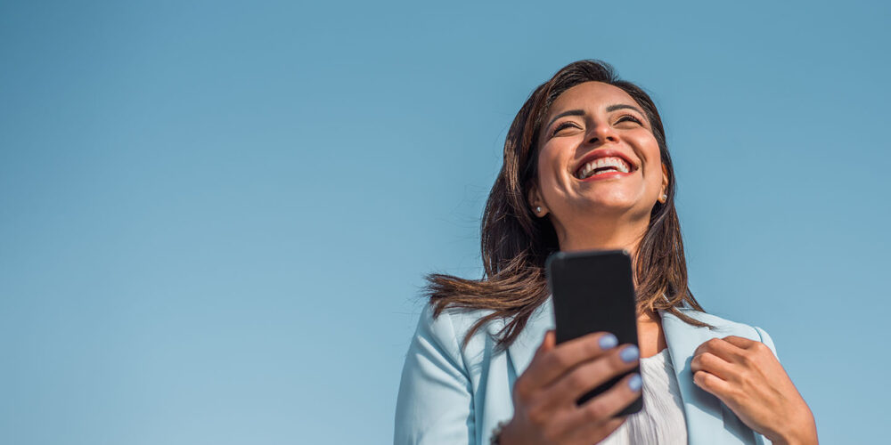 Portrait of a young Chinese girl happy with her cell phone. Copy